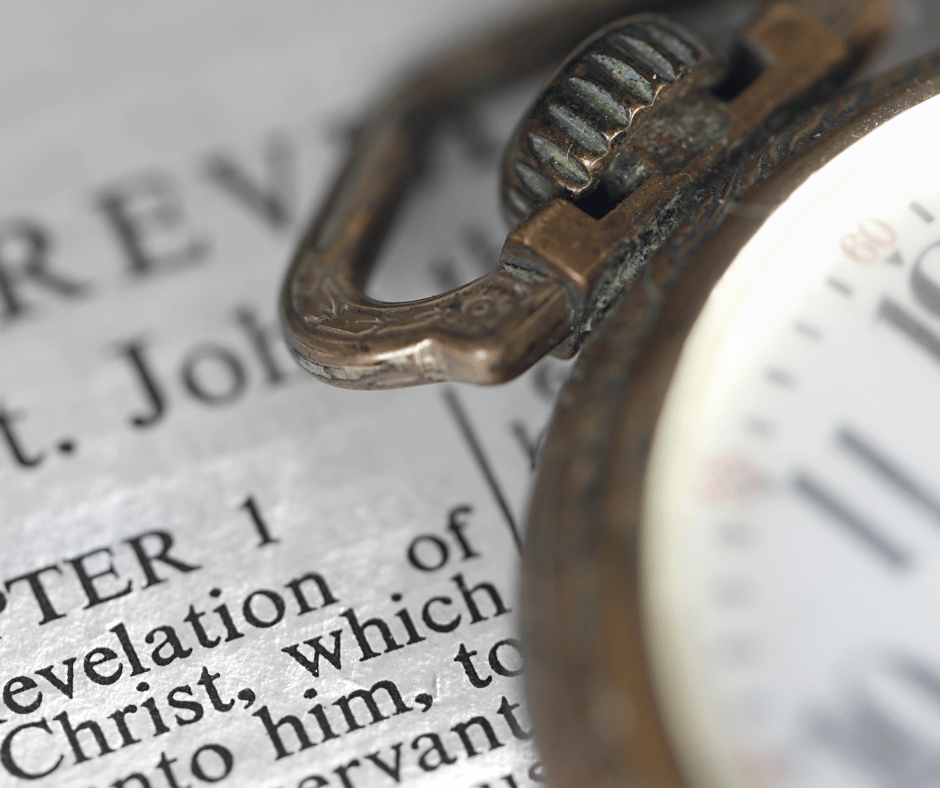 a Bible open on the book of Revelation with a watch laying on top of the page